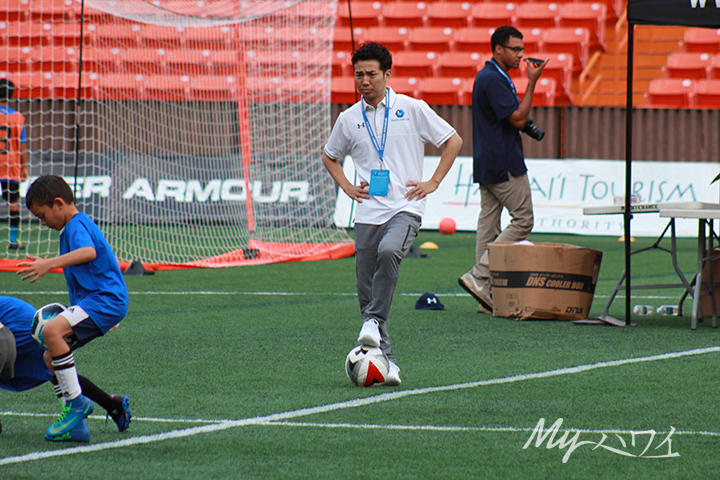 Japanese Comedian Yuji Ayabe Standing on the field with Soccer Ball