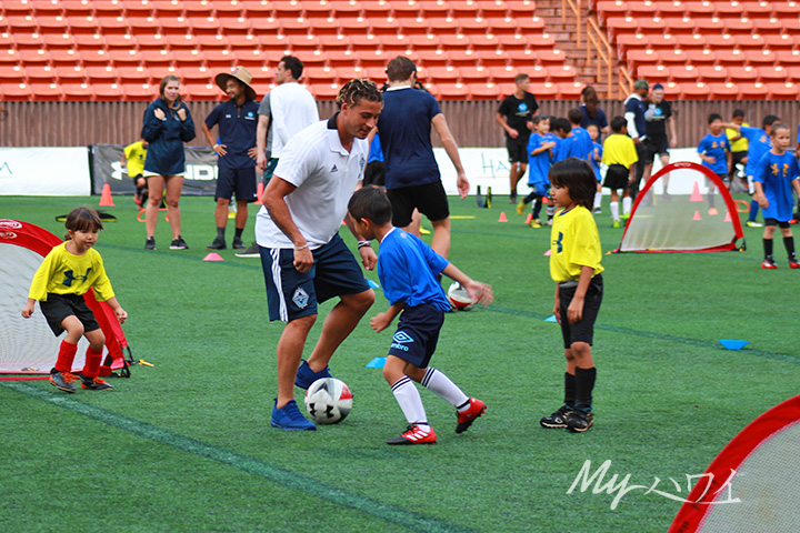 MLS player playing soccer with Children